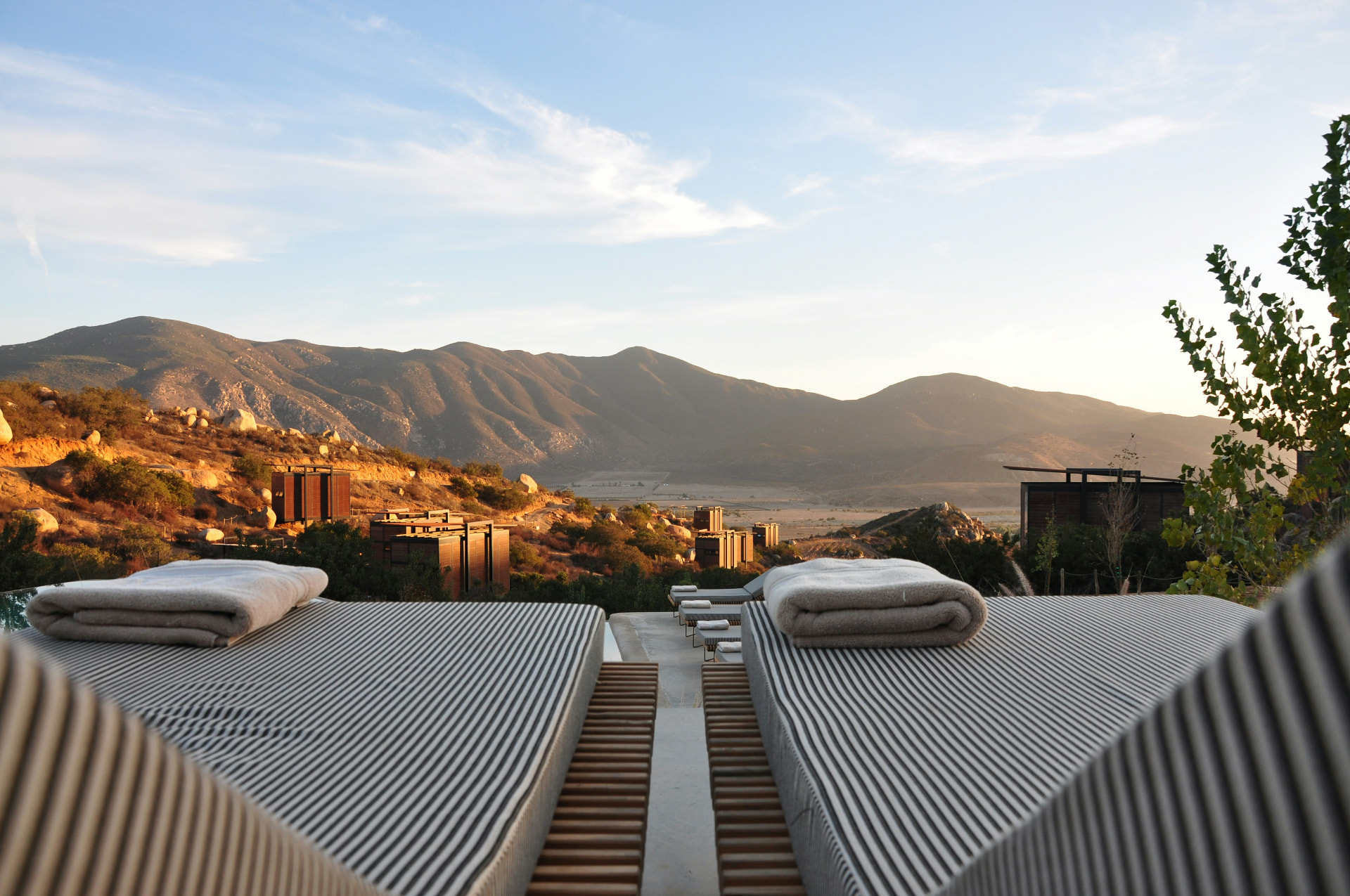 Resort terrace with loungers overlooking mountains at golden hour